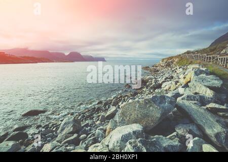 Coucher de soleil sur la côte rocheuse de la mer. Île à l'horizon. Belle nature de l'île de Senja, Norvège Banque D'Images