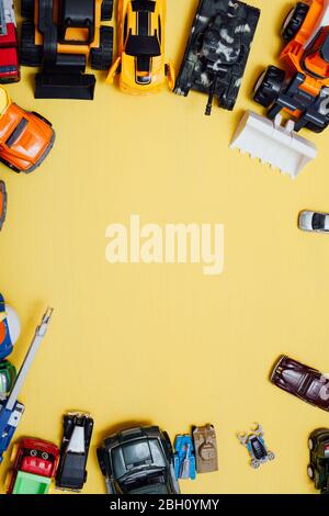 beaucoup de jouets pour enfants pour jouer garçon sur fond jaune Banque D'Images