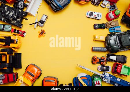 beaucoup de jouets pour enfants pour jouer garçon sur fond jaune Banque D'Images