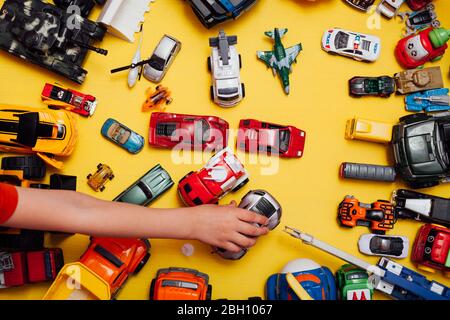 beaucoup de jouets pour enfants pour jouer garçon sur fond jaune Banque D'Images