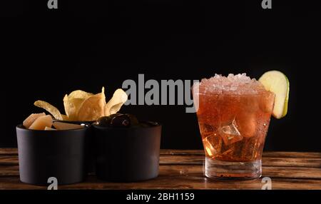 Magnifique cocktail isolé sur fond noir avec fumée de glace sèche. Vapeur blanche dans un verre froid, avec hors-d'œuvre et espace pour copier le texte. Idéal pour Banque D'Images