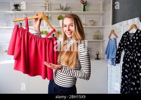 Mode blogger femme en Jean et turtleneck montrant décontracté des chemises colorées sur l'appareil photo. Styliste influenceur fille montrant des vêtements à la mode filmant vlog Banque D'Images