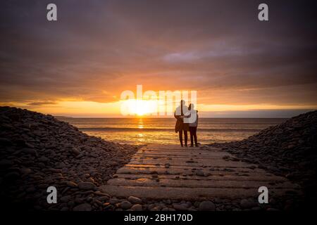 Une mère et une fille qui regardaient le coucher du soleil dans le North Devon pendant leur exercice quotidien pendant le verrouillage du coronavirus Banque D'Images