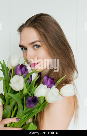 Une belle fille tient un grand bouquet. Une fille avec un bouquet de tulipes. Banque D'Images