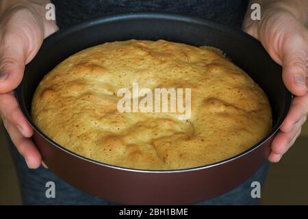 Une femme tenant une tarte fraîche cuite . Femme mettant une délicieuse tarte sur la table. La femme de ménage livre la tarte aux pommes à la table Banque D'Images