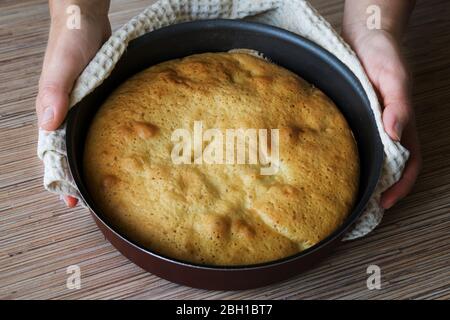 Une femme tenant une tarte fraîche cuite . Femme mettant une délicieuse tarte sur la table. La femme de ménage livre la tarte aux pommes à la table Banque D'Images