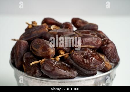 Date les fruits dans le bol sur fond blanc. Medjool séchés date fruits de palme Banque D'Images