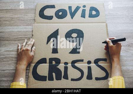 Jeune femme préparant une bannière pour la manifestation de crise économique de Covid 19 - concept de catastrophe mondiale de la pandémie de coronavirus - se concentrer sur la droite féminine Banque D'Images