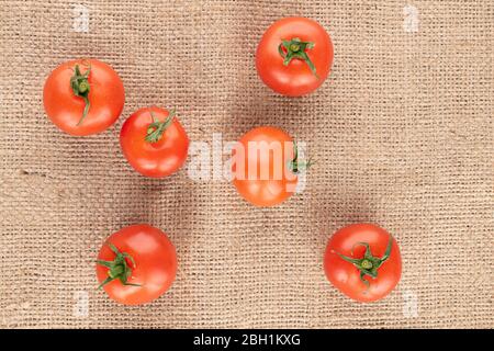 Beaucoup de tomates cerises rouges sur toile de jute Banque D'Images