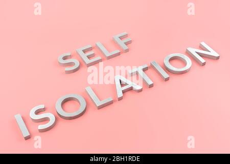les mots auto-isolation ont été posés avec des lettres en métal argenté arrière-plan rose avec perspective oblique diagonale Banque D'Images