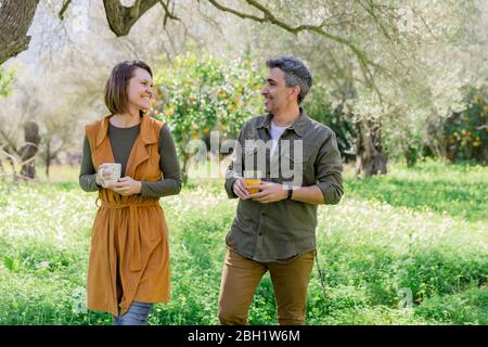 Couple heureux avec café et jus d'orange dans la campagne Banque D'Images