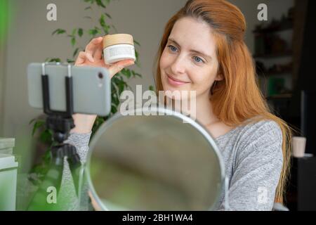 Influenceur de beauté montrant un produit cosmétique Banque D'Images