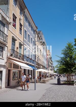 Un jeune couple marche le long d'une rue typique dans la vieille ville de Lisbonne, Portugal, après les magasins et les restaurants. Banque D'Images