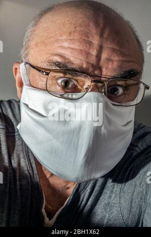 Portrait d'un homme âgé avec masque chirurgical en panique Banque D'Images