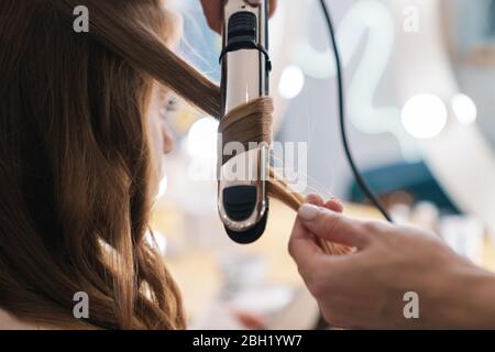 Gros plan sur un salon de coiffure qui fait des cheveux dans le salon de beauté Banque D'Images