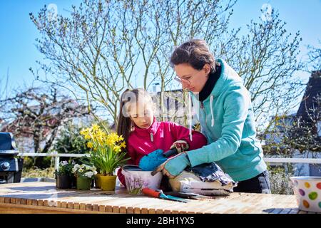 Mère et fille, planter des fleurs ensemble sur balcon Banque D'Images