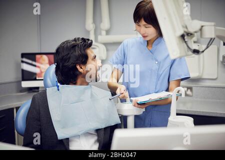 secrétaire médical préparant le traitement dentaire pour le patient Banque D'Images