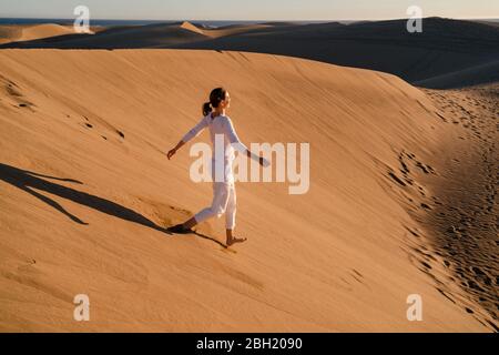 Femme descendant une dune de sable, Gran Canaria, Espagne Banque D'Images