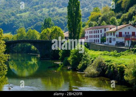 France, Pyrénées-Atlantiques, Bidarray, Pont d'Arche sur la rivière Nive avec maisons de village en arrière-plan Banque D'Images