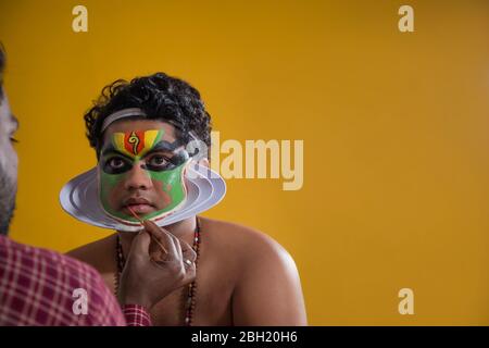 Danseur Kathakali obtenant ses dernières étapes de maquillage fait. Banque D'Images