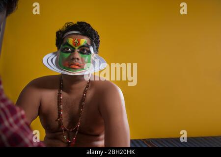 Danseur Kathakali assis et obtenir ses dernières étapes de maquillage.fait. Banque D'Images