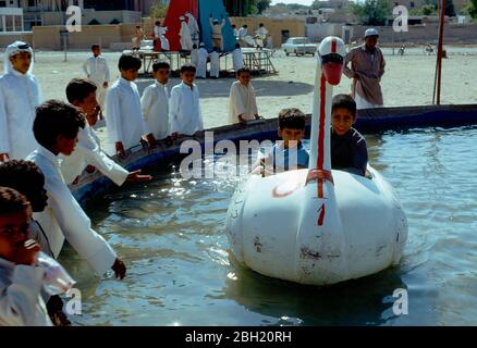 Qatar, Doha, enfants jouant sur la promenade de l'eau. Banque D'Images