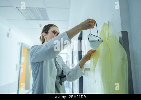 Médecin prenant un masque respiratoire à l'hôpital Banque D'Images