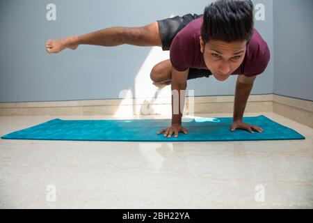 Homme faisant des exercices de yoga avancés à la maison. Banque D'Images