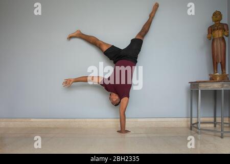 Homme faisant main contre le mur à la maison. Banque D'Images