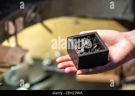 Bague dans une boîte à bijoux, main de ferrrier d'or femelle dans son atelier Banque D'Images