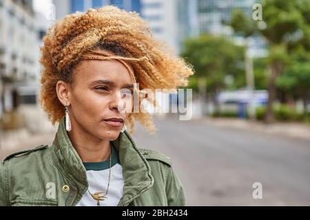 Portrait d'une jeune femme avec une coiffure afro dans la ville Banque D'Images