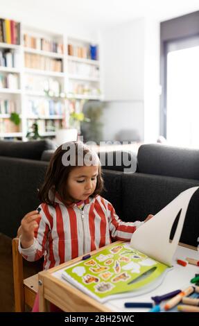 Petite fille couchée jouant dans le salon à la maison Banque D'Images