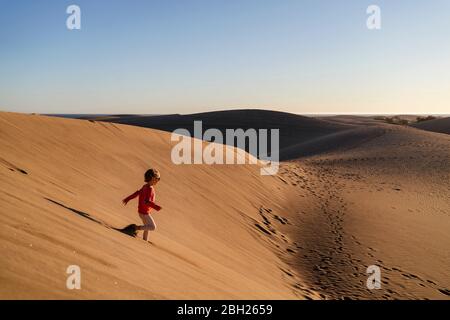 Fille en train de courir sur une dune de sable, Gran Canaria, Espagne Banque D'Images