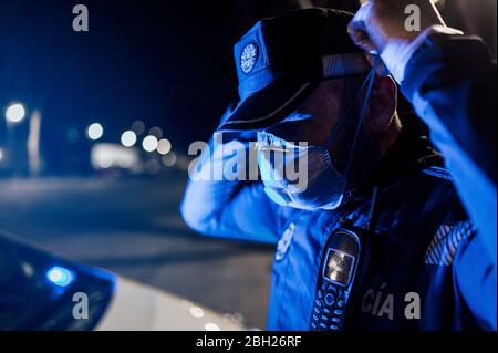 Portrait d'un policier portant un masque et des gants de protection la nuit Banque D'Images