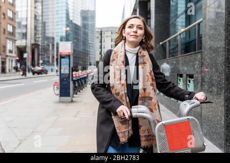Femme en ville utilisant un vélo de location, Londres, Royaume-Uni Banque D'Images