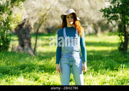 Portrait d'une femme à tête rouge portant un chapeau à la campagne Banque D'Images