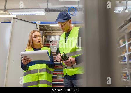 Deux électriciens discutent du plan Banque D'Images