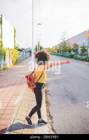 Jeune femme avec hairdo afro en randonnée dans la ville Banque D'Images