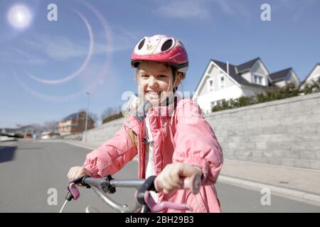 Portrait de la petite fille heureuse avec vélo dans le logement Banque D'Images