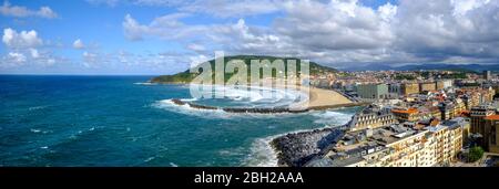 Espagne, Gipuzkoa, San Sebastian, Panorama des bâtiments de la ville entourant la plage de Zurriola avec colline d'Urgull en arrière-plan Banque D'Images