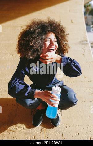 Portrait d'une jeune femme élégante et heureuse ayant une pause de l'entraînement Banque D'Images