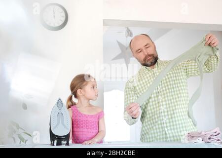 Père et fille repassant ensemble à la maison Banque D'Images