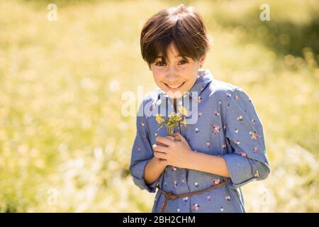 Portrait de la fillette heureuse tenant des fleurs sauvages Banque D'Images