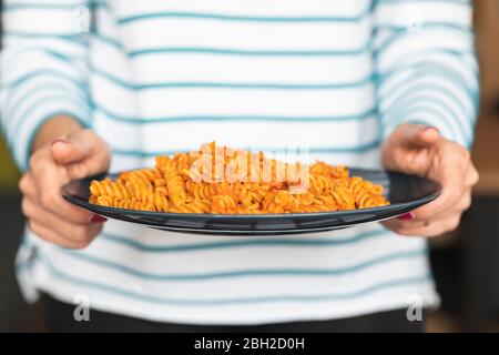 Femme tenant une assiette avec des pâtes Banque D'Images