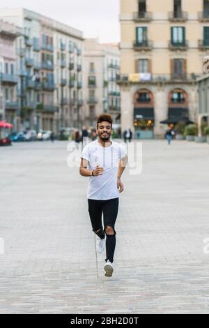 Portrait d'un jeune homme en train de rire sur une place, Barcelone, Espagne Banque D'Images