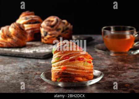 Kraffins aux raisins secs, fruits confits et graines de pavot, arrosés de sucre en poudre. Banque D'Images