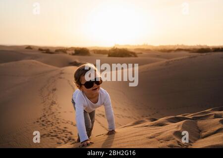 Fille rampant sur une dune de sable, Gran Canaria, Espagne Banque D'Images