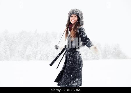 Portrait de la jeune femme heureuse dansant dans le paysage d'hiver Banque D'Images