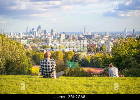 Vue arrière des touristes qui ont vue sur la ville de Londres depuis la colline du Parlement à Hampstead Heath Banque D'Images