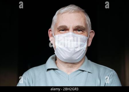 Portrait d'un homme âgé portant un masque à la maison Banque D'Images